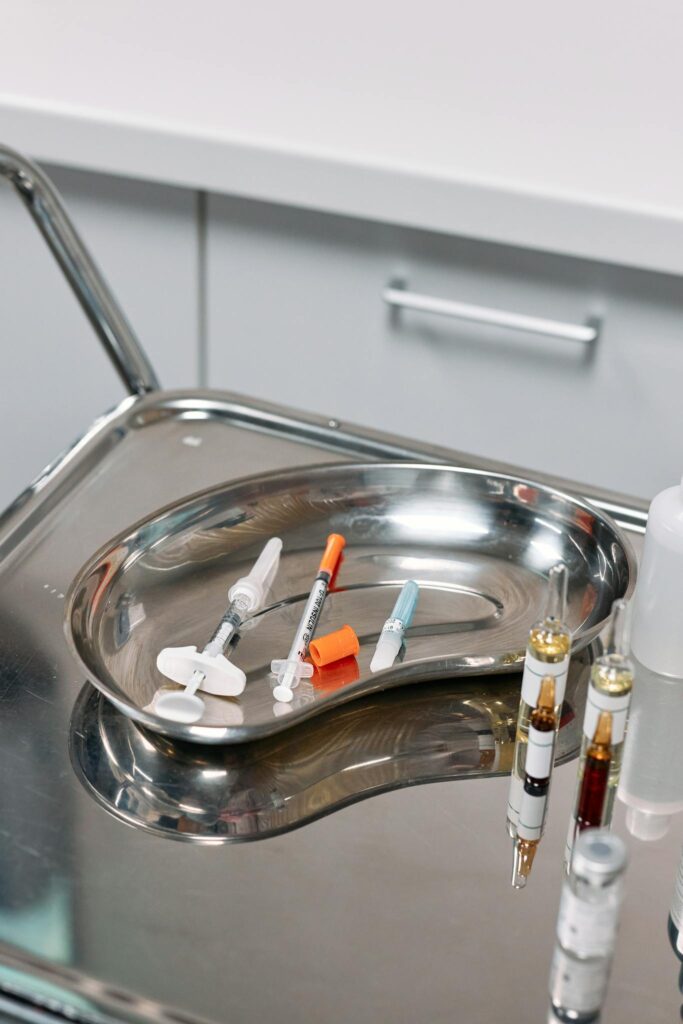 Close-up of syringes and medical tools on a silver tray. Ideal for healthcare and medical themes.